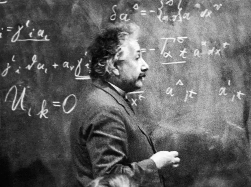 Albert Einstein standing at a blackboard covered in mathematical calculations, 1921. Hulton Archive.
