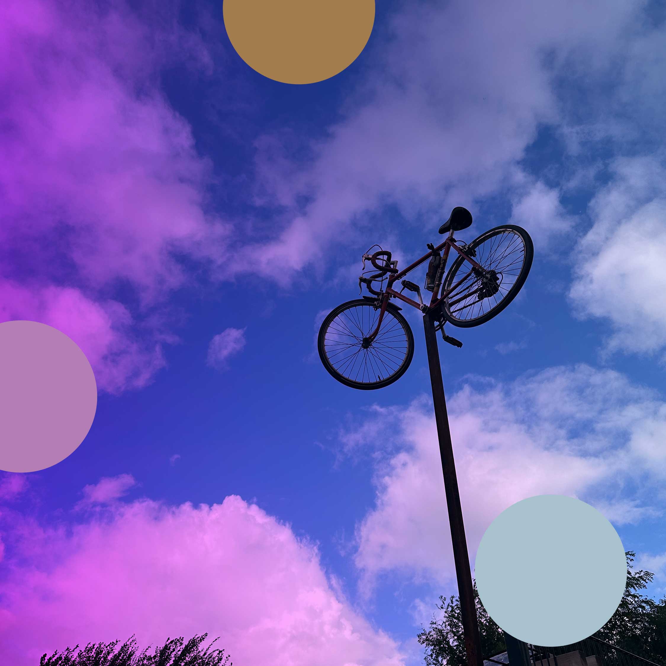 A road bicycle mounted high on a pole against a purple and blue sky, with coloured circles overlaid.